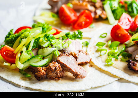 Gesunde Minibar Tortillas mit gegrilltem Huhn, Fleisch, Soße, frisches Gemüse auf hellgrauen Hintergrund, Ansicht von oben. Gesundes Essen für ein Picknick. Stockfoto