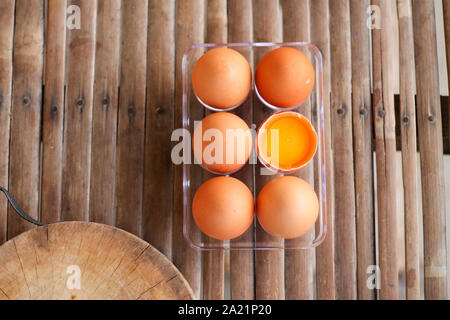 Von oben betrachtet, eine der sechs Gebrochene Eier auf einem Bambusparkett. Stockfoto
