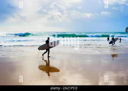 Surfer mit surfbrettern am Strand. Moody Wetter. Algarve, Portugal Stockfoto