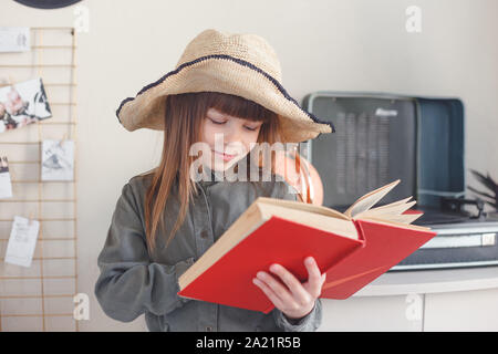 Kinder lieben es, zu träumen. Die Mädchen in der Hut mit dem Buch selbst präsentiert sich als die Heldin der Geschichte. Stockfoto