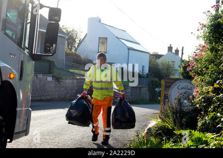 Rat-Arbeiter mit schwarzen Plastiktüten und Lkw sammeln von Hausmüll in der Ortschaft Marloes Pembrokeshire in West Wales UK KATHY DEWITT Stockfoto