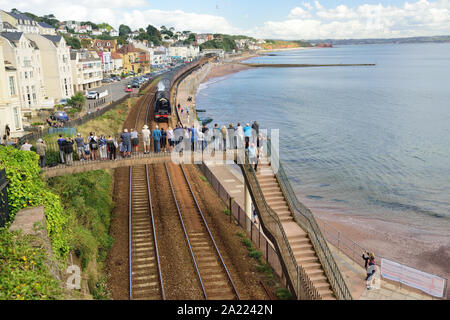 Menschen auf einer Fußgängerbrücke beobachten die Eisenbahntour des Königlichen Herzogtums durch Dawlish, die von der LMS Pacific No. 6233 'Herzogin von Sutherland' gezogen wird. 01.09.2019. Stockfoto