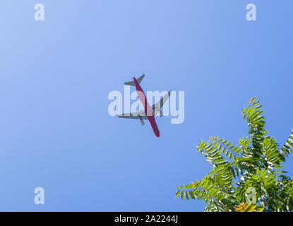 Das Flugzeug fliegt über den blauen Himmel. Low Angle View. Platz für eine Nachricht. Stockfoto