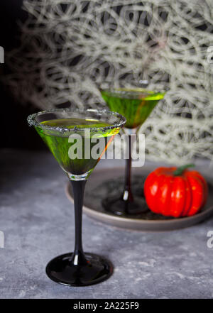 Zwei Gläser mit grünen zombie Cocktail, Kürbis für Halloween Party in der grauen Tabelle. Stockfoto