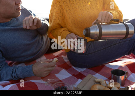 Paar mit einem Picknick am Meer Stockfoto