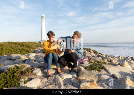 Paar mit einem Picknick am Meer Stockfoto