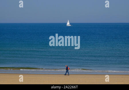 Person zu Fuß am Strand von holkham, North Norfolk, England Stockfoto