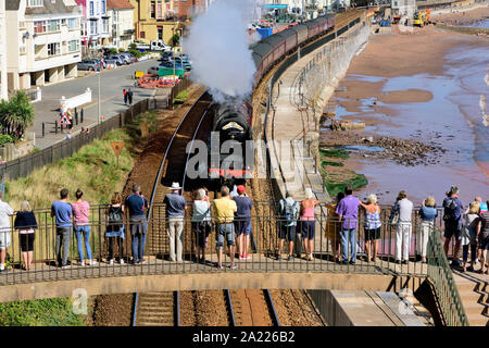 Menschen auf einer Fußgängerbrücke beobachten die Eisenbahntour des Königlichen Herzogtums durch Dawlish, die von der LMS Pacific No. 6233 'Herzogin von Sutherland' gezogen wird. 15.09.2019. Stockfoto