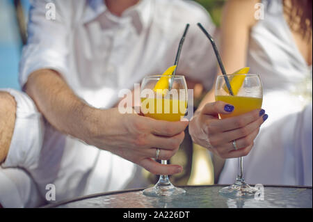 Hände mit bunten Cocktails am Strand Stockfoto