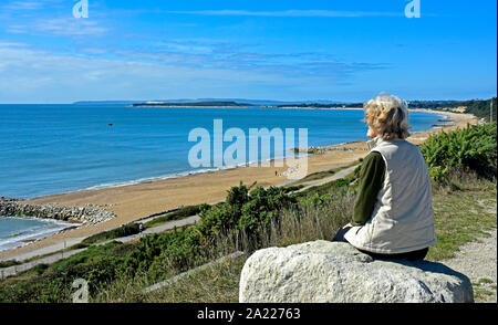 Highcliffe - Dorset - Sommer - Besucher auf einem Felsen sitzen - genießen Sie den Blick über die Bucht - entspannend Stockfoto