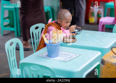 Junger buddhistischer Mönch junge Essen Street Food in Yangon, Myanmar. Bugdshism am beliebtesten sind, die Religion mit der Burma. Stockfoto