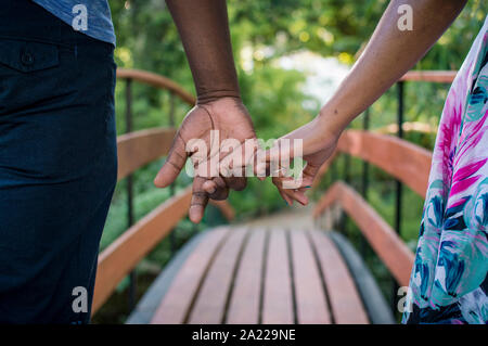 Junges Paar Hand in Hand im Park Stockfoto