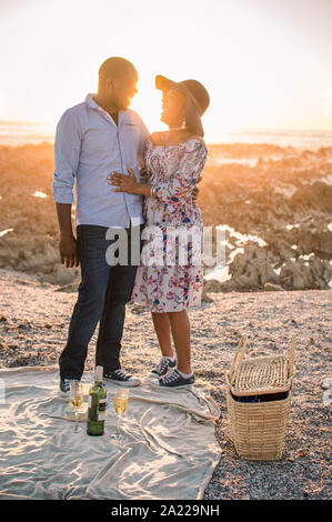 Junges Paar mit Picknick am Strand Stockfoto