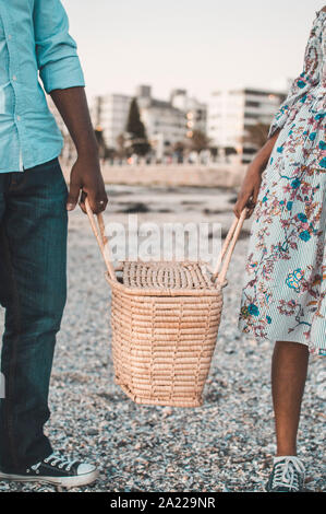 Junges Paar mit Picknick am Strand Stockfoto