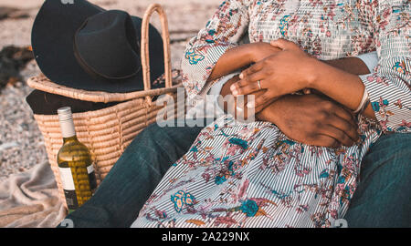 Junges Paar mit Picknick am Strand Stockfoto