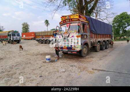 Lokale LKW-Fahrer seine Tata Lkw Reinigung am Straßenrand in der Nähe der Kaziranga, Golaghat Bezirk, Bochagaon, Assam, Indien Stockfoto