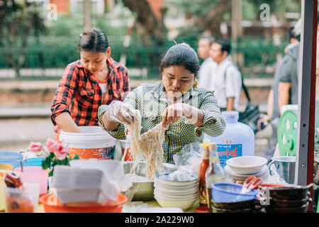 Burmesischen Frau vorbereiten und Verkaufen traditionelles Essen auf der Straße von Yangon. Stockfoto