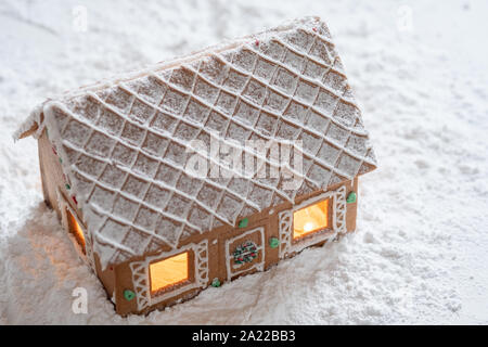 Lebkuchen-Haus im Schnee mit funkelnden silbernen hellen Hintergrund Stockfoto