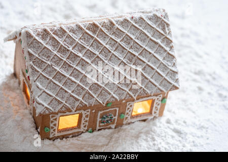 Lebkuchen-Haus im Schnee mit funkelnden silbernen hellen Hintergrund Stockfoto