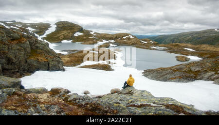 Panorama der norwegischen Landschaft mit schneebedeckten Bergen und Clear Lake in der Nähe der berühmten Aurlandsvegen (Bjorgavegen) Mountain Road, Aurland, Norwegen Stockfoto