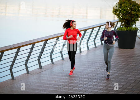 Landschaft von zwei weiblichen Jogger Verfolgung ihrer Aktivität in städtischen im Freien Stockfoto