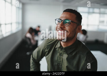 Porträt einer stattlichen casual Geschäftsmann mit schwarzen Brillen in Büro lächeln Stockfoto