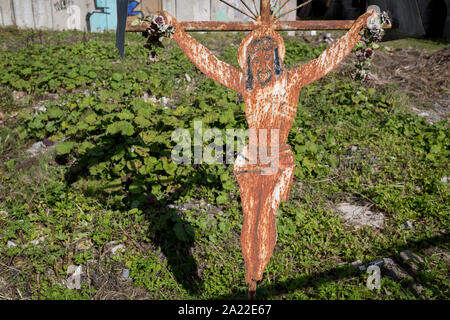 Ein Blech Jesus Kruzifix (eine populäre lokale Kopie von einem historischen Rutherian Kirche) außerhalb einer verlassenen Industriegebäude am Stadtrand von Jaworki, am 20. September 2019, in der Nähe von Szczawnica, Malopolska, Polen. Das Dorf eines florierenden Rutherian Gemeinschaft war einmal in der Nähe Biala Woda wo über 100 Farmen wurden - die Reste davon sind noch heute zu sehen. Ein hölzernes Kreuz mit Christus Schneiden von Blech überlebte der Kultur. Ähnlich wie Kreuze und Kapellen kann in der Umgangssprache der Weißen Wasser in der Rumänisch, Ukrainisch oder Ostslowakei Karpaten gefunden werden. Stockfoto