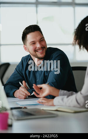 Erfolgreiche lächelnden Jungen corporate Geschäftsmann diskutieren neue Business Plan, mithilfe von Diagrammen mit seinem Kollegen Stockfoto