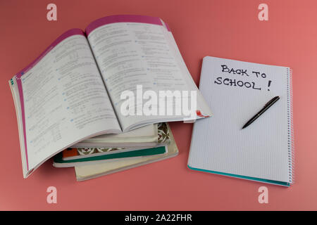Zurück zum Konzept der Schule, Bücher und öffnen Sie Notizbuch mit den Worten zurück in die Schule, auf einem rosa Hintergrund Stockfoto