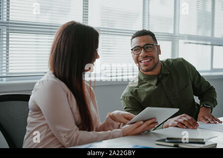 Junge Unternehmer mit einem digitalen tablet Informationen mit ihren Kollegen in einem modernen Büro besprechen Stockfoto