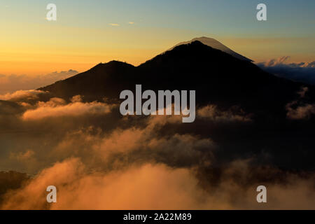 Malerischer Blick auf Wolken und Nebel bei Sonnenaufgang vom Gipfel des Mount Batur (Vulkan) Kintamani, Bali, Indonesien Stockfoto