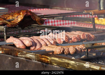 Würstchen aufgereiht auf der Nehrung und auf heißen Kohlen kochen Stockfoto