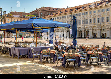 Ein Kellner serviert Kaffee in einem Restaurant Im eleganten barocken Piazza San Carlo eine der wichtigsten Stadtplätze, Turin, Italien Stockfoto