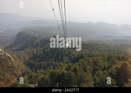 Blick auf die Berge von der Kabine mit der Seilbahn auf die Spitze des Tahtali und das Meer in der Nähe der Küste von Kemer, Antalya, Türkei Stockfoto