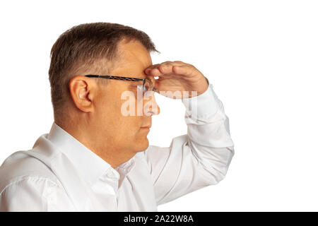 Ein älterer Mann seine Augen zum Schutz vor der Sonne mit der Hand in die Ferne schaut. Stockfoto