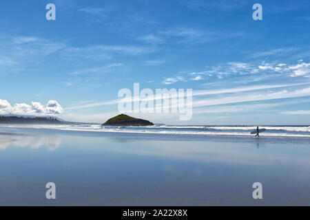 Ein Surfer ist zu Fuß entlang der schönen langen Strand in der nähe von Tofino, Britisch-Kolumbien, Kanada Stockfoto