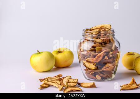 Chips Äpfel im Glas und Stücke dieser Früchte auf einem weißen Hintergrund, horizontale Ausrichtung, Kopieren Raum Stockfoto