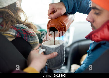 Glücklich, multi-ethnischen Freunde der kaukasischen und indischer Herkunft, die Weihnachten Geschenke und zu Fuß in einer verschneiten Park während der Ferien Stockfoto