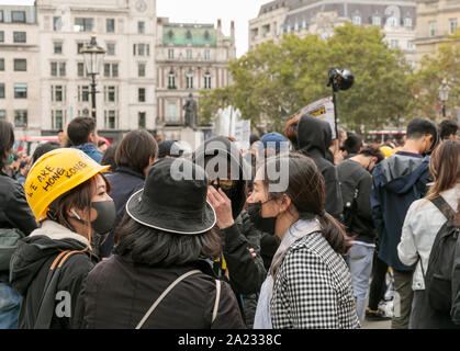 Demonstrant tragen Gesichtsmaske und gelb Hard hat die Worte "Wir sind Hongkong" Lager auf der Demonstration gegen die chinesische Herrschaft in Hongkong, Trafalgar Square, London, 28. September 2019. Hunderte pf Leute nach dem Marsch von der chinesischen Konsulat sammeln Stockfoto