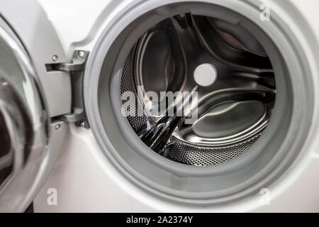 Tür der leeren Waschmaschine mit einer Trommel und einem horizontalen Ladung Wäsche geöffnet Stockfoto