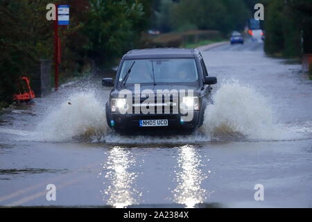 Ein Land Rover macht einen Splash, wie es fährt durch einen überfluteten Abschnitt der Straße zwischen Castleford & Allerton Bywater Stockfoto