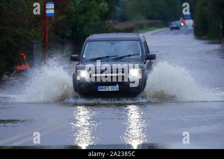 Ein Land Rover macht einen Splash, wie es fährt durch einen überfluteten Abschnitt der Straße zwischen Castleford & Allerton Bywater Stockfoto