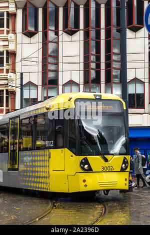 MANCHESTER, England - 30 September, 2018: Die regnerischen Herbst Tag in Manchester, UK, gelb Metrolink tram am Piccadilly Gärten Stockfoto