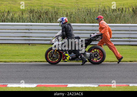 James Ellison (Bike Teufel Versicherung Sweda MV Agusta team) sein Rad schieben nach Crash in Oulton Park, Großbritannien Stockfoto
