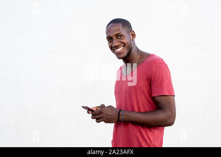 Porträt eines afrikanischen Mann SMS auf seinem Mobiltelefon Stockfoto