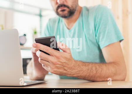 Zweistufige Authentifizierung und Überprüfung online internet Konto Login Konzept. Casual nach kaukasischen Freiberufler Mann ist mit Smartphone und Laptop c Stockfoto