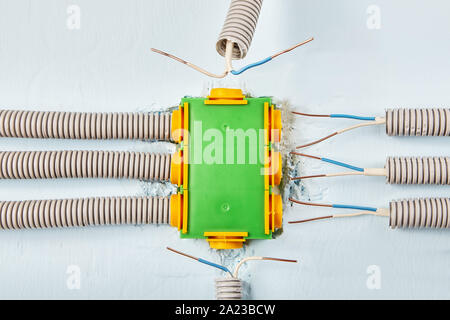Home elektrische Leitungen sind in einem Rohr, das an das Stromverteilungssystem angeschlossen wird ausgeblendet. Installation von einem an der Wand montierten elektrischen Stockfoto