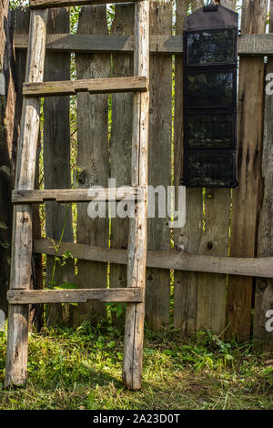 Tragbare falten Solar Batterie panel hängt an einem Holzzaun in der Nähe gibt es einen der Leiter im Freien in der Landschaft Stockfoto