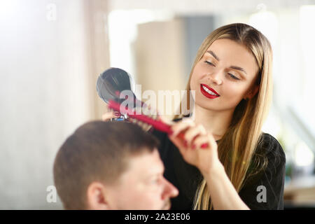 Junge Mädchen Friseur Holding Trockner und Haarbürste Stockfoto