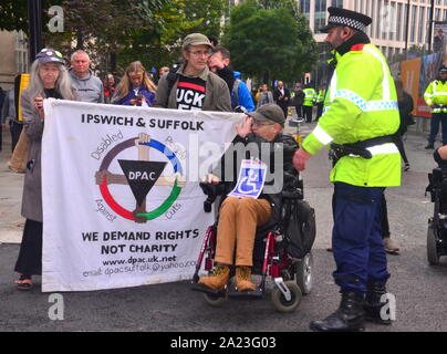 Ein Polizist fragt, behinderte Menschen gegen Sozialabbau (DPAC) Demonstranten zurück vor dem Parteitag der Konservativen Partei 2019, am Tag 2 in Manchester, UK. Stockfoto